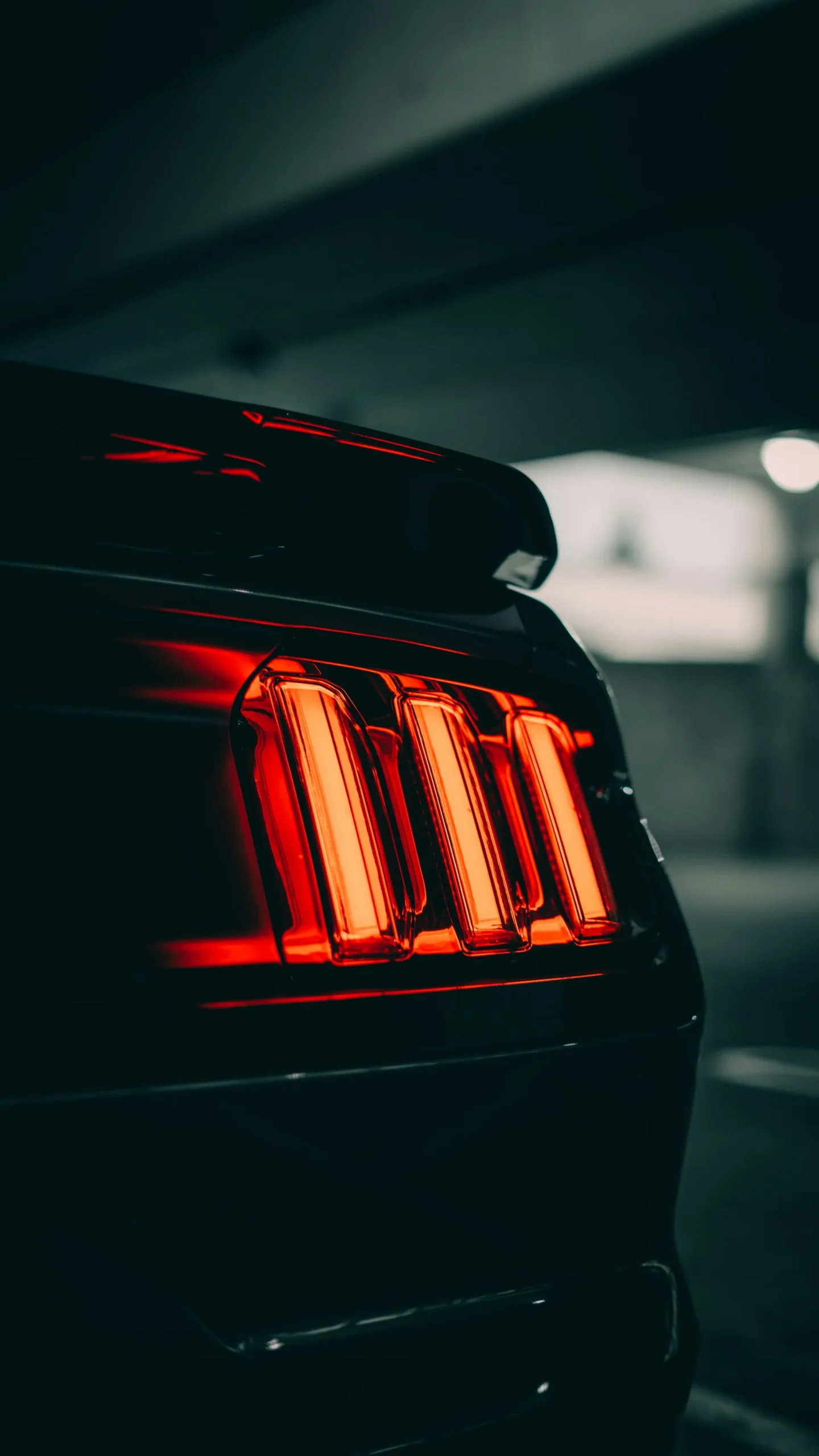 A close-up view of the rear taillights of a car, illuminated in red.