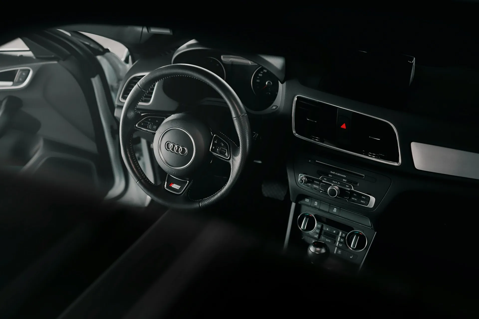 Interior view of an Audi car, showcasing the steering wheel, dashboard, and control panel.