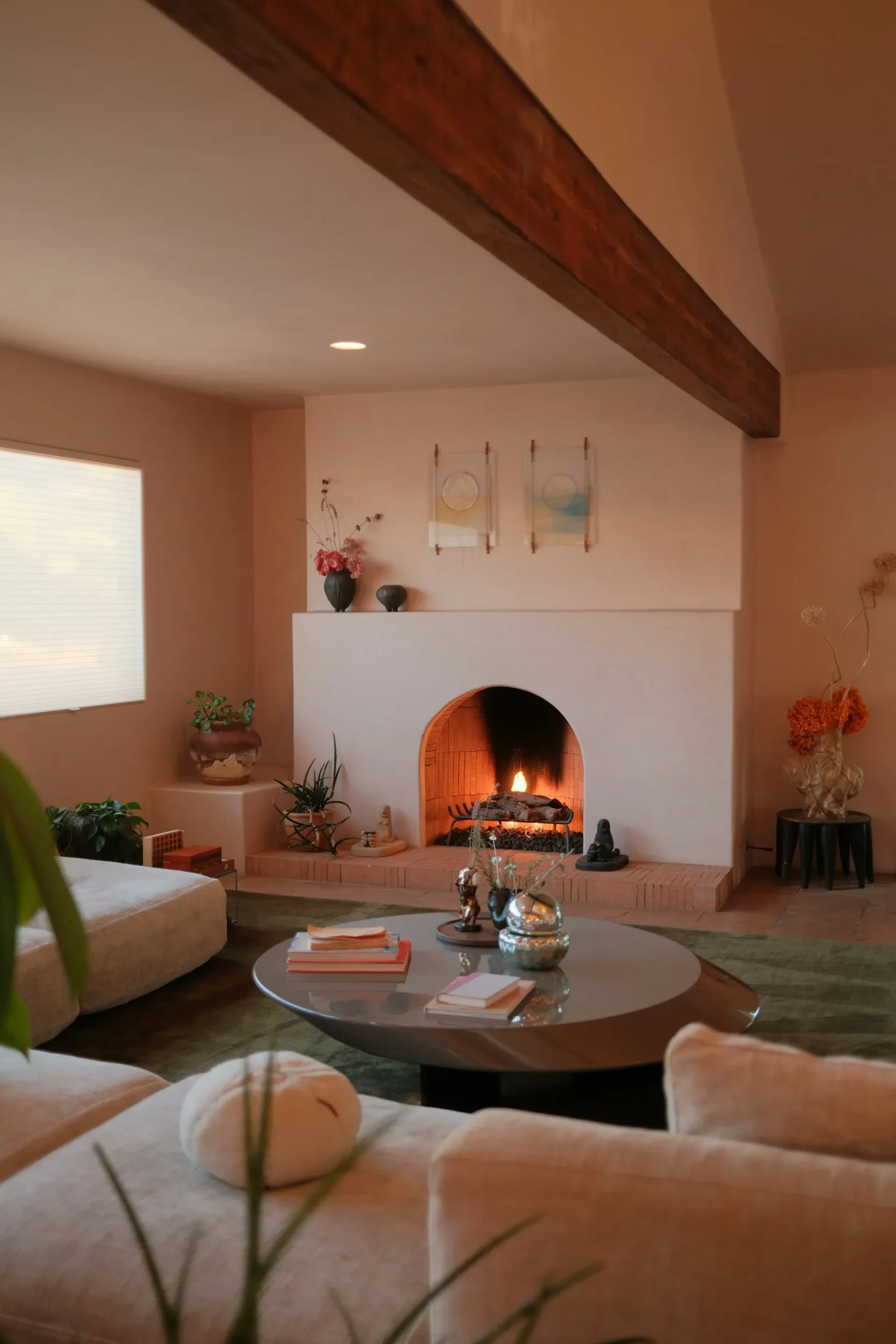 Modern living room with fireplace, plants, and cozy seating.